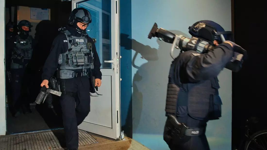 Spezialkräfte verlassen bei einer großangelegten Razzia der Bundespolizei und Landespolizei Brandenburg ein Haus in Weißensee. - Bild: Paul Zinken/dpa
