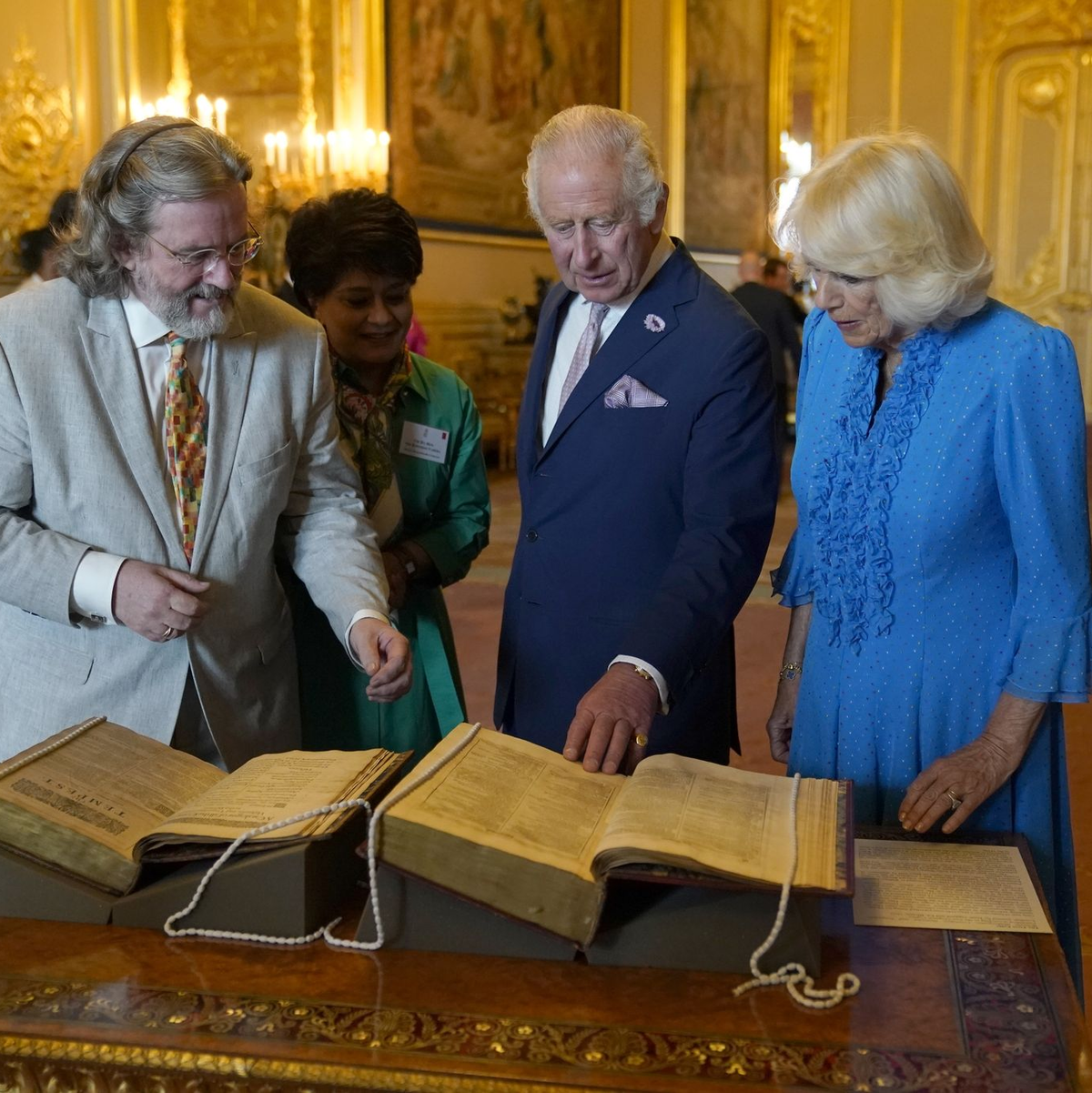 König Charles III. und Königin Camilla betrachten das erste Shakespeare-Folio während eines Empfangs auf Schloss Windsor. - Foto: Andrew Matthews/PA Wire/dpa