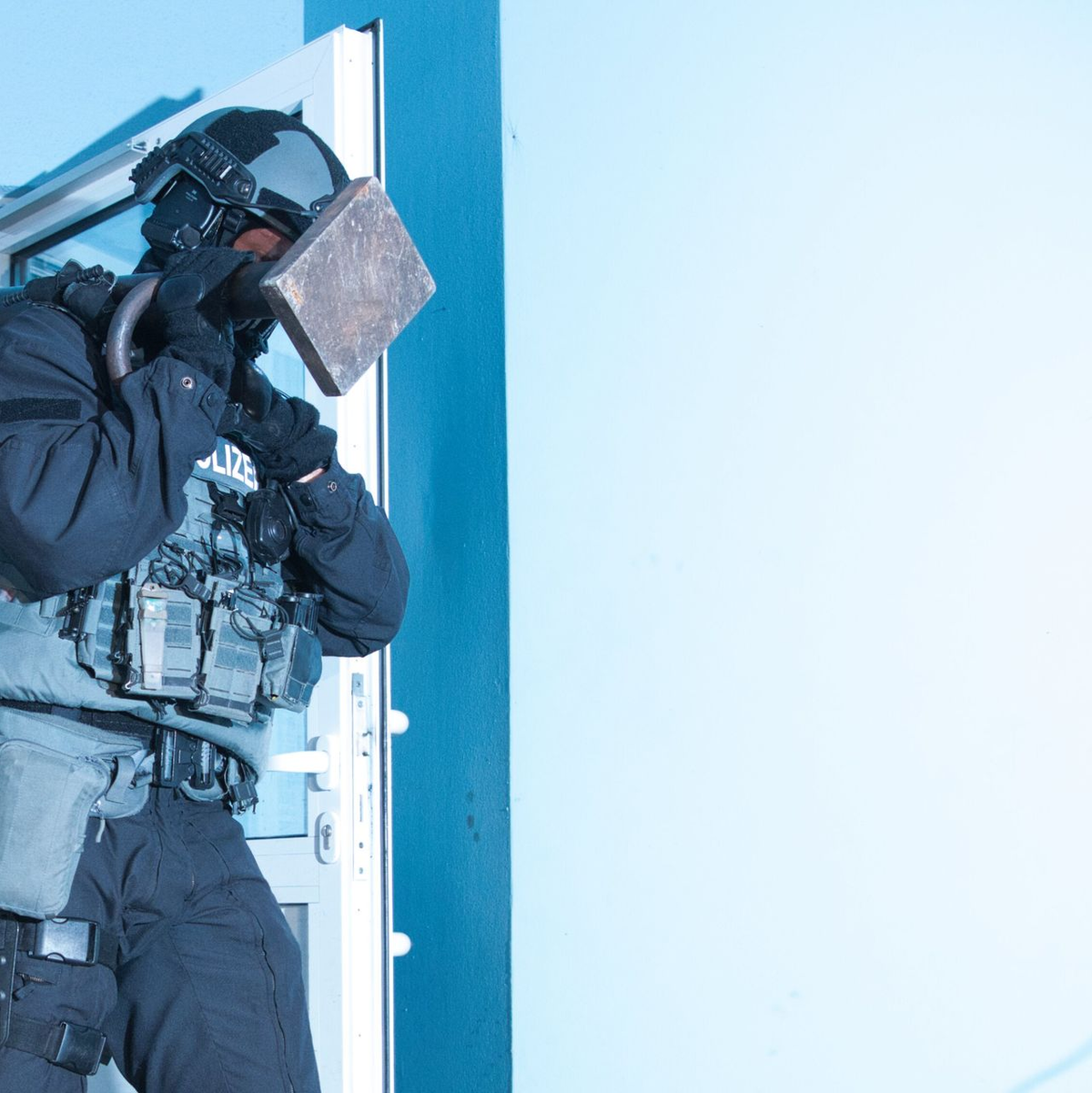 Ein Polizist verlässt bei einer Razzia ein Haus in Berlin. - Foto: Paul Zinken/dpa