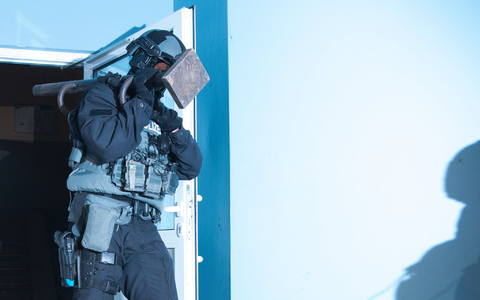 Ein Polizist verlässt bei einer Razzia ein Haus in Berlin. - Foto: Paul Zinken/dpa