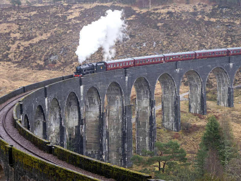 Der erste Jacobite Express der Saison 2022 überquert das Glenfinnan-Viadukt auf seinem Weg von Fort William nach Mallaig. Die «Harry Potter»-Filme machten die Zugstrecke über das Glenfinnan-Viadukt in Schottland weltberühmt. - Foto: Jane Barlow/PA Archive/dpa