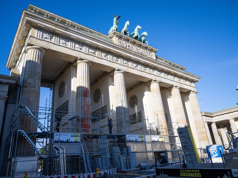 Auf einer Seite des Brandenburger Tors wird ein Baugerüst aufgebaut, um die Folgen der Farbattacke zu beseitigen. - Foto: Christophe Gateau/dpa
