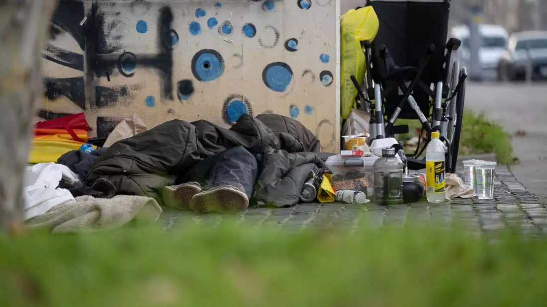 Eine Person liegt in der Innenstadt unter einem Schlafsack. Die Zahl der Wohnungslosen in Deutschland ist neuen Berechnungen zufolge im vergangenen Jahr deutlich gestiegen. - Bild: Marijan Murat/dpa