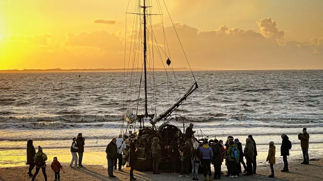 Ein am Weststrand der Insel Norderney gestrandetes Segelschiff mit Schaulustigen. - Bild: Volker Bartels/dpa