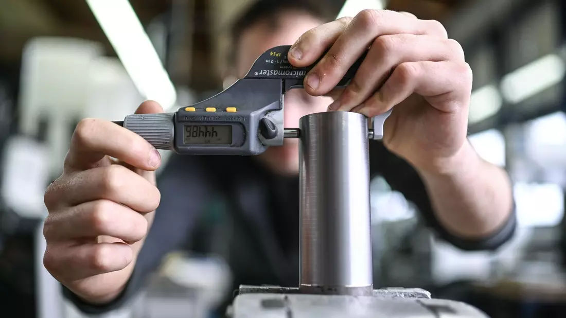Ein Auszubildender im Metall-Handwerk misst in einem Ausbildungszentrum die Dicke eines Werkstücks. Viele Ausbildungsverträge werden vorzeitig gelöst. - Bild: Felix Kästle/dpa