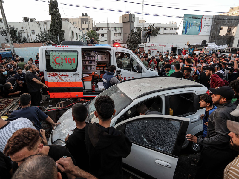 Menschen versammeln sich um einen Krankenwagen, nachdem dieser vor dem Eingang des Schifa-Krankenhaus angegriffen wurde. - Foto: -/XinHua/dpa