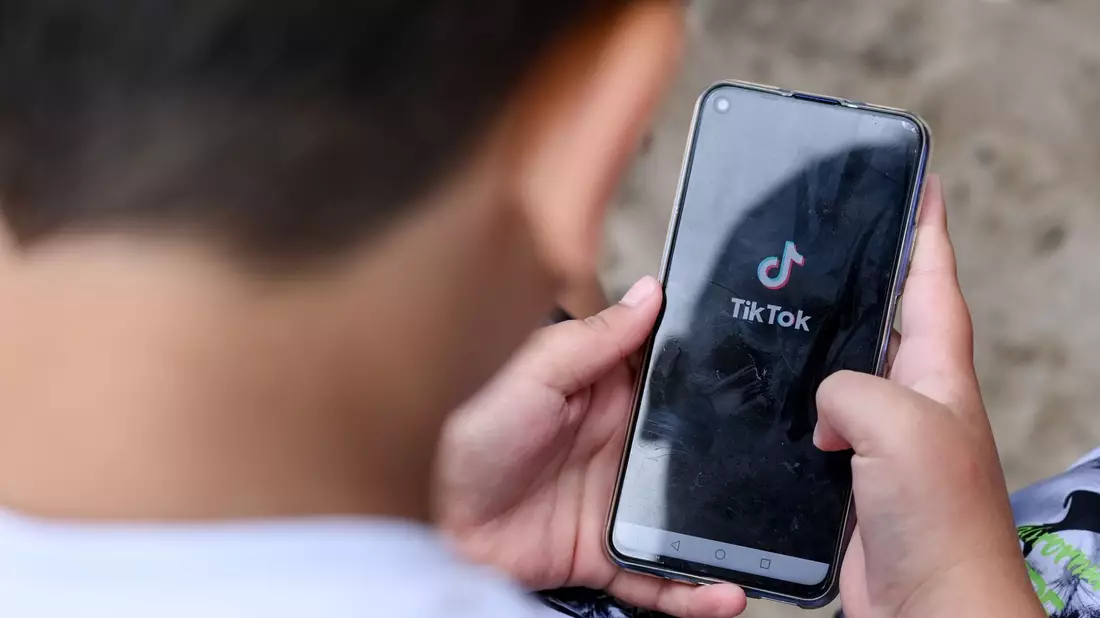 Ein Junge schaut auf ein Smartphone: Die EU-Kommission verlangt Infos von Plattformbetreibern zu ihren Jugendschutz-Aktivitäten. - Bild: Jens Kalaene/dpa-Zentralbild/dpa