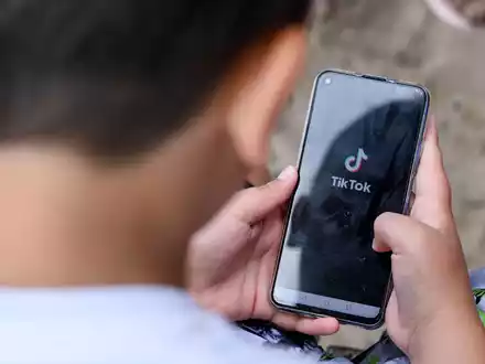 Ein Junge schaut auf ein Smartphone: Die EU-Kommission verlangt Infos von Plattformbetreibern zu ihren Jugendschutz-Aktivitäten. - Foto: Jens Kalaene/dpa-Zentralbild/dpa