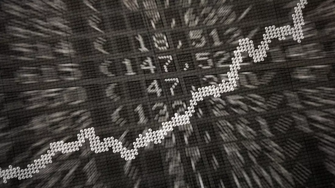 Die große Anzeige in der Börse zeigt die Dax-Kurve und verschiedene Börsenkurse: ETFs werden börsentäglich gehandelt. - Bild: Daniel Reinhardt/dpa