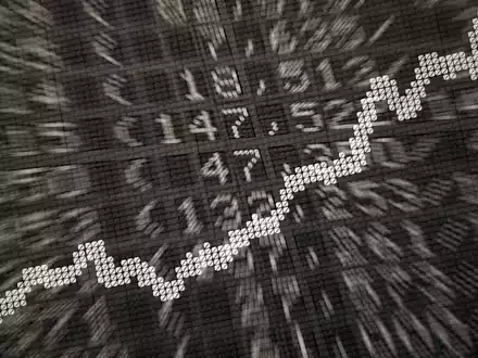 Die große Anzeige in der Börse zeigt die Dax-Kurve und verschiedene Börsenkurse: ETFs werden börsentäglich gehandelt. - Foto: Daniel Reinhardt/dpa