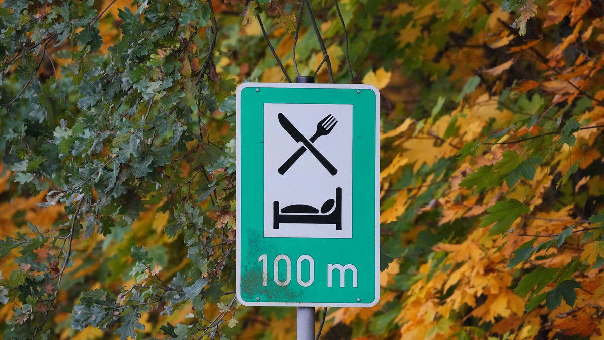 Ein Schild weist auf die Möglichkeit zum Essen und Übernachten hin: Die Übernachtungszahlen steigen. - Foto: Soeren Stache/dpa