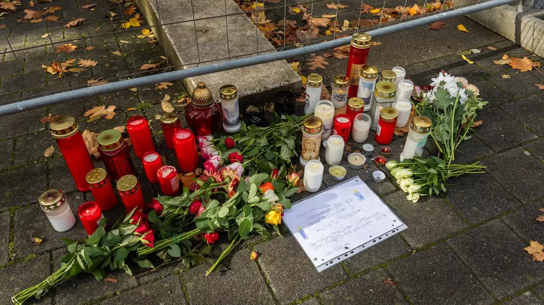 Blumen und Kerzen liegen vor der Waldbachschule in Offenburg. Die Sonderkommission «Mühlbach» ermittelt in dem Fall. - Bild: Philipp von Ditfurth/dpa