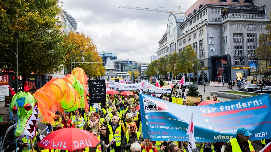 Der Zug einer Demonstration zum Streik im Einzelhandel zieht am KaDeWe in Berlin vorbei. - Bild: Christoph Soeder/dpa
