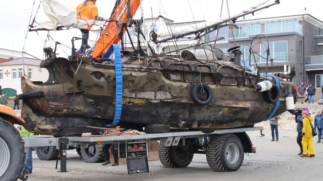 Das gestrandete Segelschiff «Wibo» wird auf der Insel Norderney auf einen Anhänger verladen. - Bild: Volker Bartels/dpa