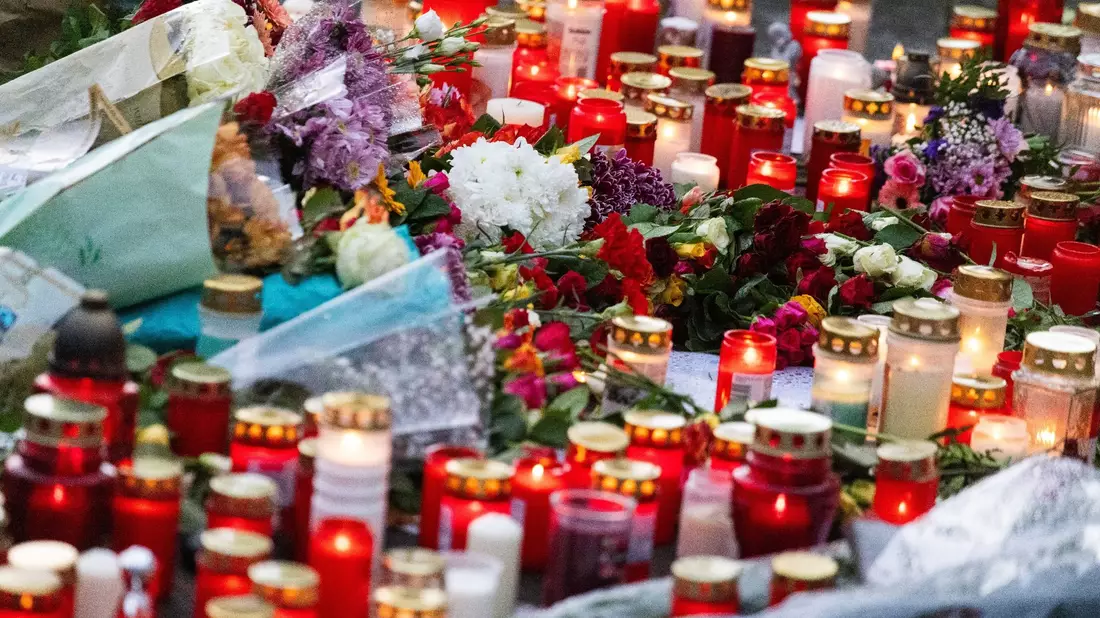 Blumen und Kerzen liegen vor der Waldbachschule in Offenburg. - Bild: Philipp von Ditfurth/dpa