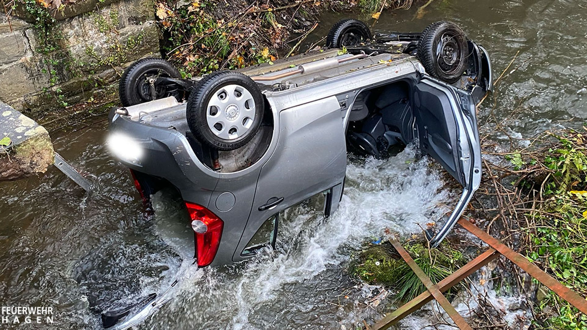 Ein Auto liegt im Fluss Volme. Der Wagen war von der Straße abgekommen und hatte ein Geländer durchbrochen. - Foto: --/Feuerwehr Hagen/dpa
