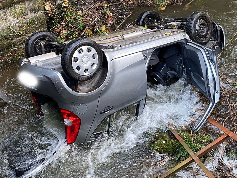 Ein Auto liegt im Fluss Volme. Der Wagen war von der Straße abgekommen und hatte ein Geländer durchbrochen. - Foto: --/Feuerwehr Hagen/dpa