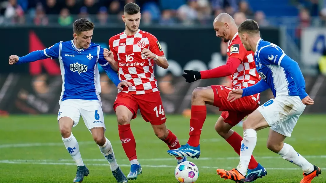 Darmstadt (blaue Trikots) und Mainz trennten sich torlos. - Bild: Uwe Anspach/dpa