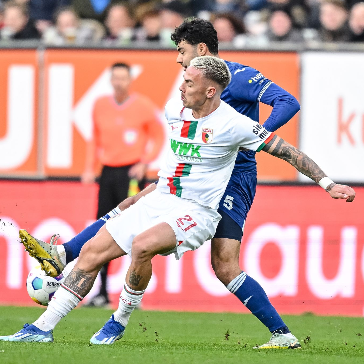 Der Augsburger Phillip Tietz (l) im Zweikampf mit Hoffenheims Ozan Kabak. - Foto: Harry Langer/dpa