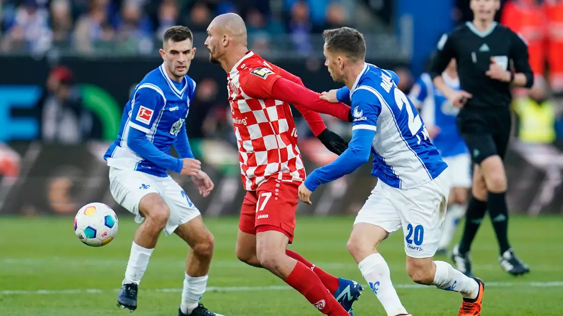 Ludovic Ajorque (M) und seine Mainzer nehmen einen Punkt aus Darmstadt mit. - Bild: Uwe Anspach/dpa