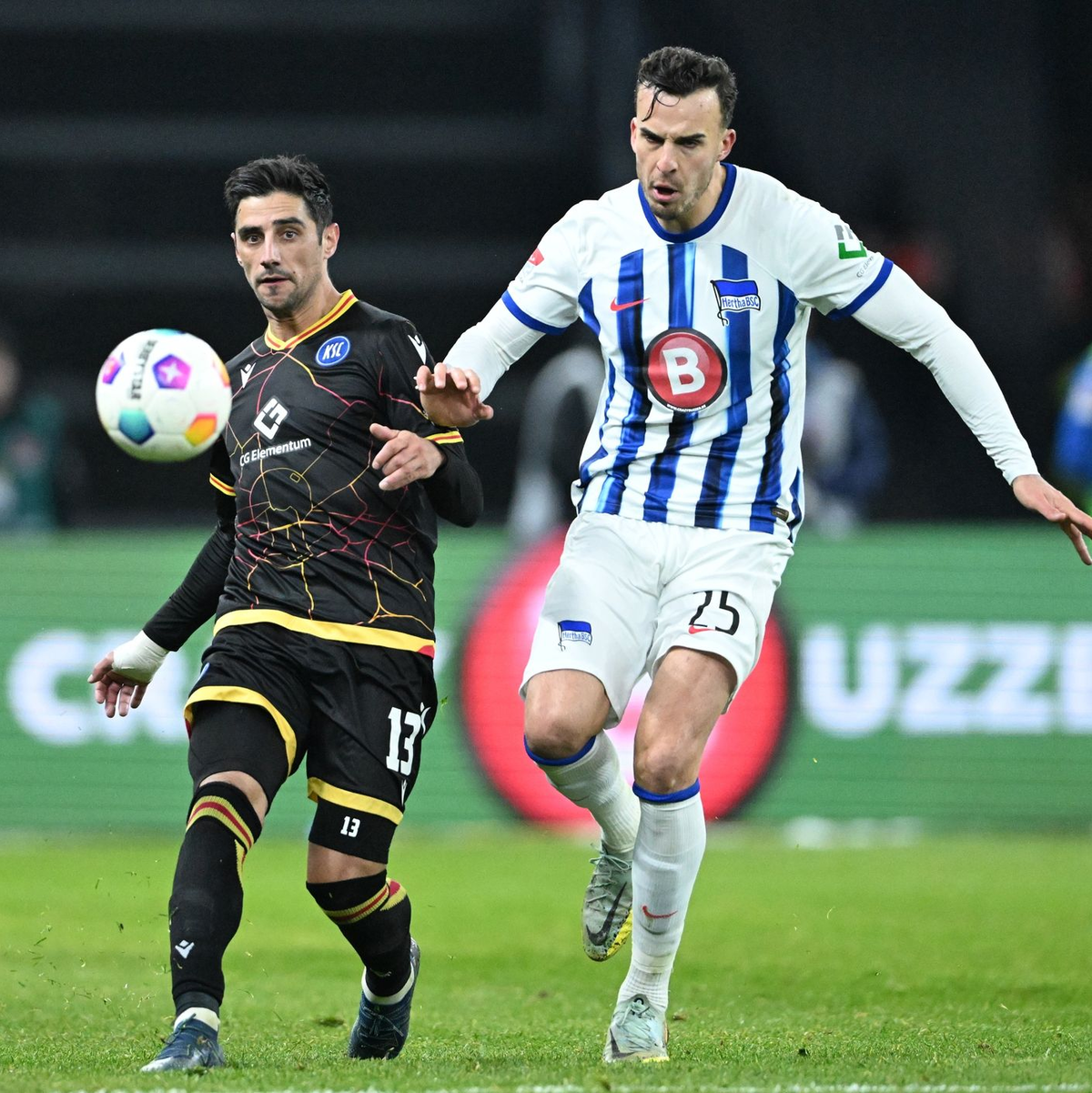 Karlsruhes Lars Stindl (l) im Laufduell mit dem Herthaner Haris Tabakovic. - Foto: Soeren Stache/dpa