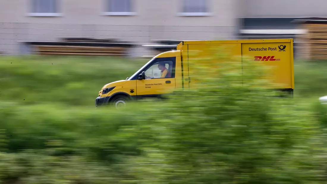 Ein Zusteller des Post-Konzerns DHL stellt mit einem elektrisch betriebenen Fahrzeug (Streetscooter) Post zu. - Bild: Jan Woitas/dpa