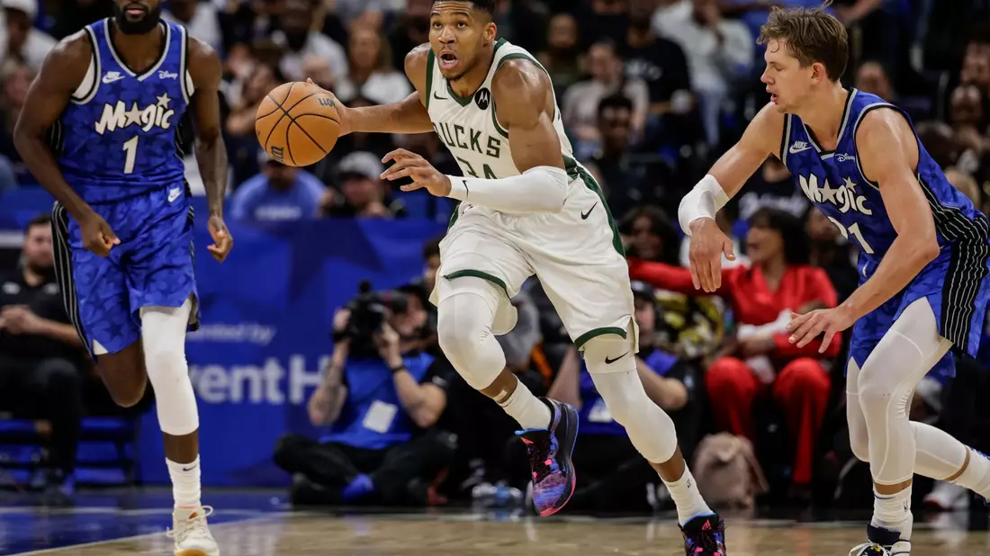 Milwaukees Giannis Antetokounmpo (M) dribbelt an Orlandos Jonathan Isaac (l) und Center Moritz Wagner (21) vorbei. - Bild: Kevin Kolczynski/AP/dpa