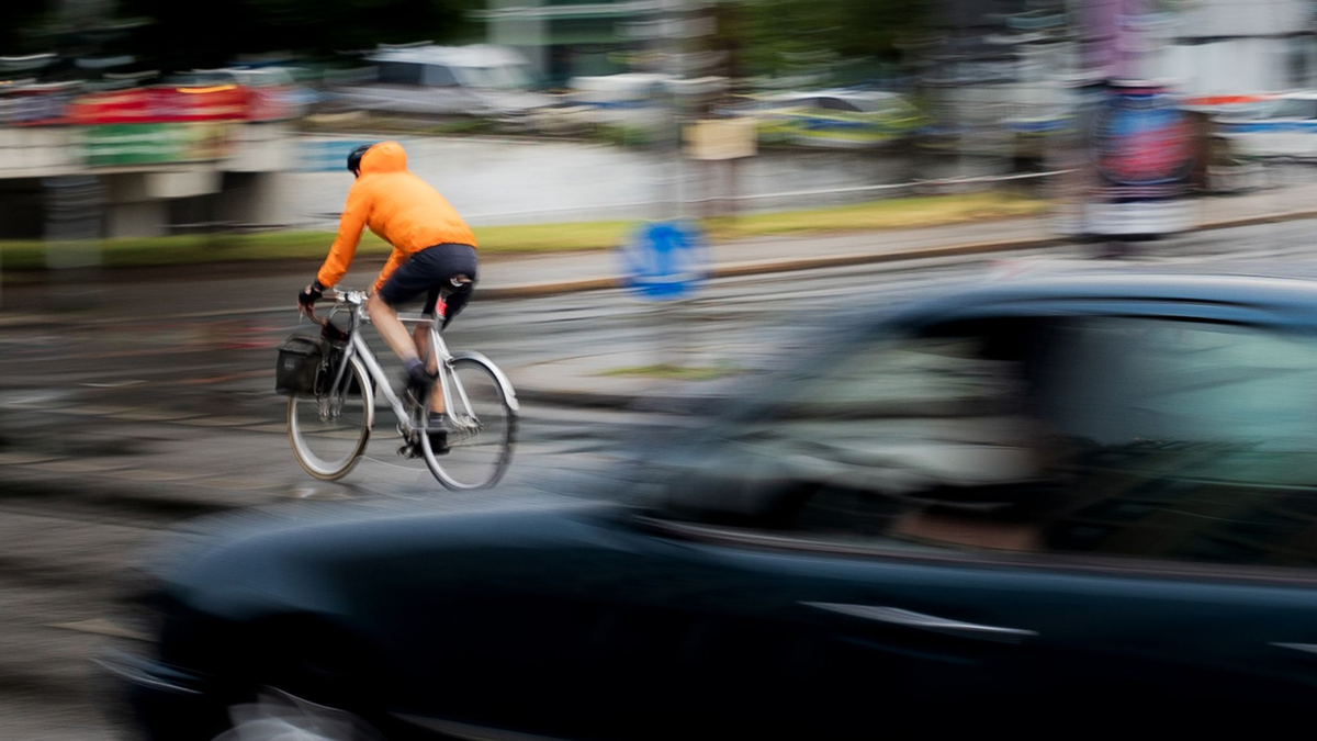 Ein Pkw fährt hinter einem Fahrradfahrer an einer Kreuzung einer Hauptverkehrsstraße in Berlin. Inwieweit Maßnahmen zur Verbesserung der Verkehrssicherheit befürwortet werden, hängt auch stark vom Alter ab. - Foto: Carsten Koall/dpa