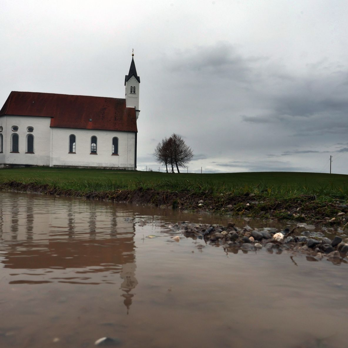 Regenwolken über der Wallfahrtskirche Sankt Alban im bayerischen Aitrang. - Foto: Karl-Josef Hildenbrand/dpa