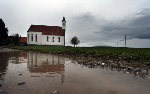 Regenwolken über der Wallfahrtskirche Sankt Alban im bayerischen Aitrang. - Foto: Karl-Josef Hildenbrand/dpa
