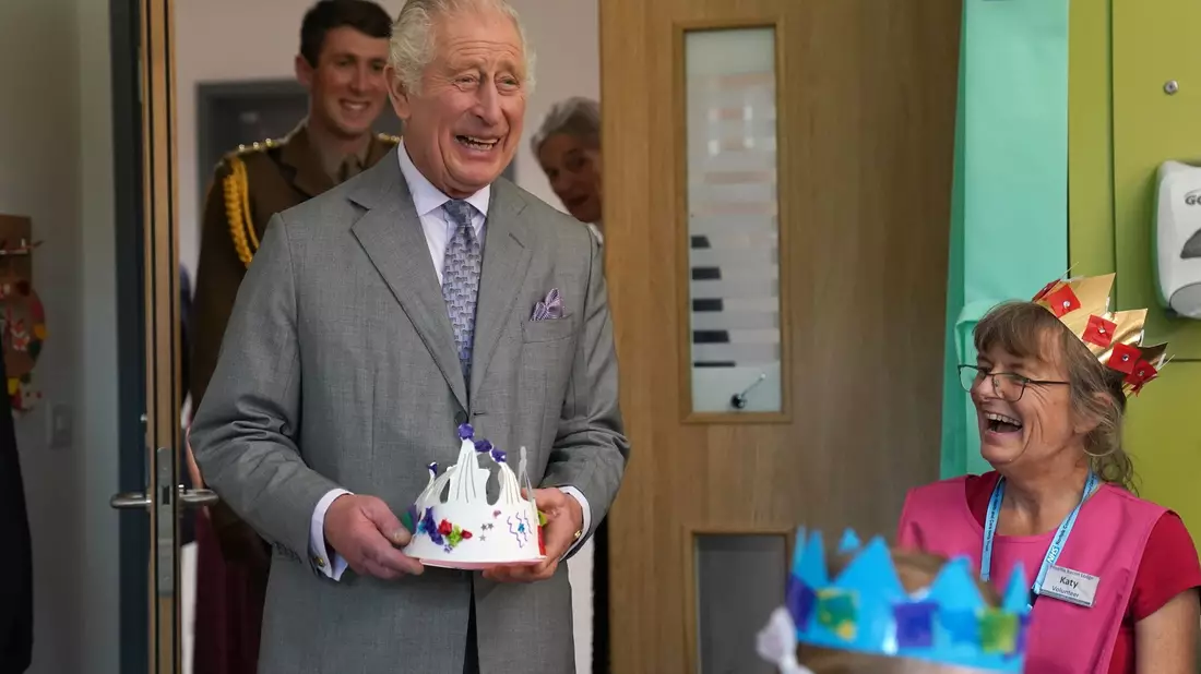 König mit Papierkrone: Charles III. bei der Eröffnung des Priscilla Bacon Lodge Hospizes in Norwich. - Bild: Jacob King/PA Wire/dpa
