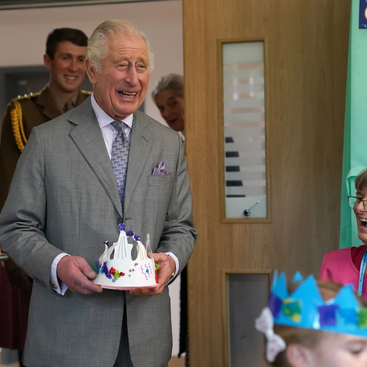 König mit Papierkrone: Charles III. bei der Eröffnung des Priscilla Bacon Lodge Hospizes in Norwich. - Foto: Jacob King/PA Wire/dpa