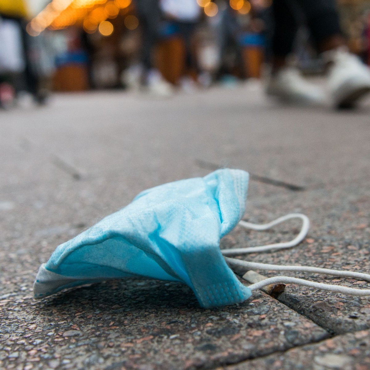 Eine Maske liegt in der Innenstadt von Hamburg auf dem Boden. - Foto: Daniel Bockwoldt/dpa