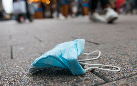 Eine Maske liegt in der Innenstadt von Hamburg auf dem Boden. - Foto: Daniel Bockwoldt/dpa