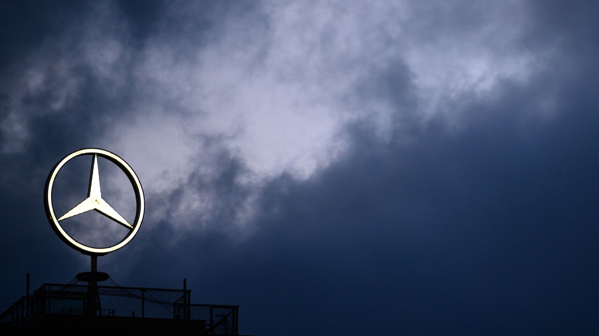 Dunkle Wolken über dem Mercedes Stern. - Foto: Sebastian Gollnow/dpa