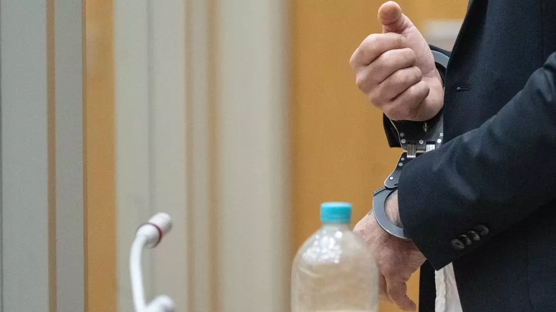 Der Angeklagte steht in Handschellen in einem Saal des Oberlandesgerichts Stuttgart. - Bild: -/dpa