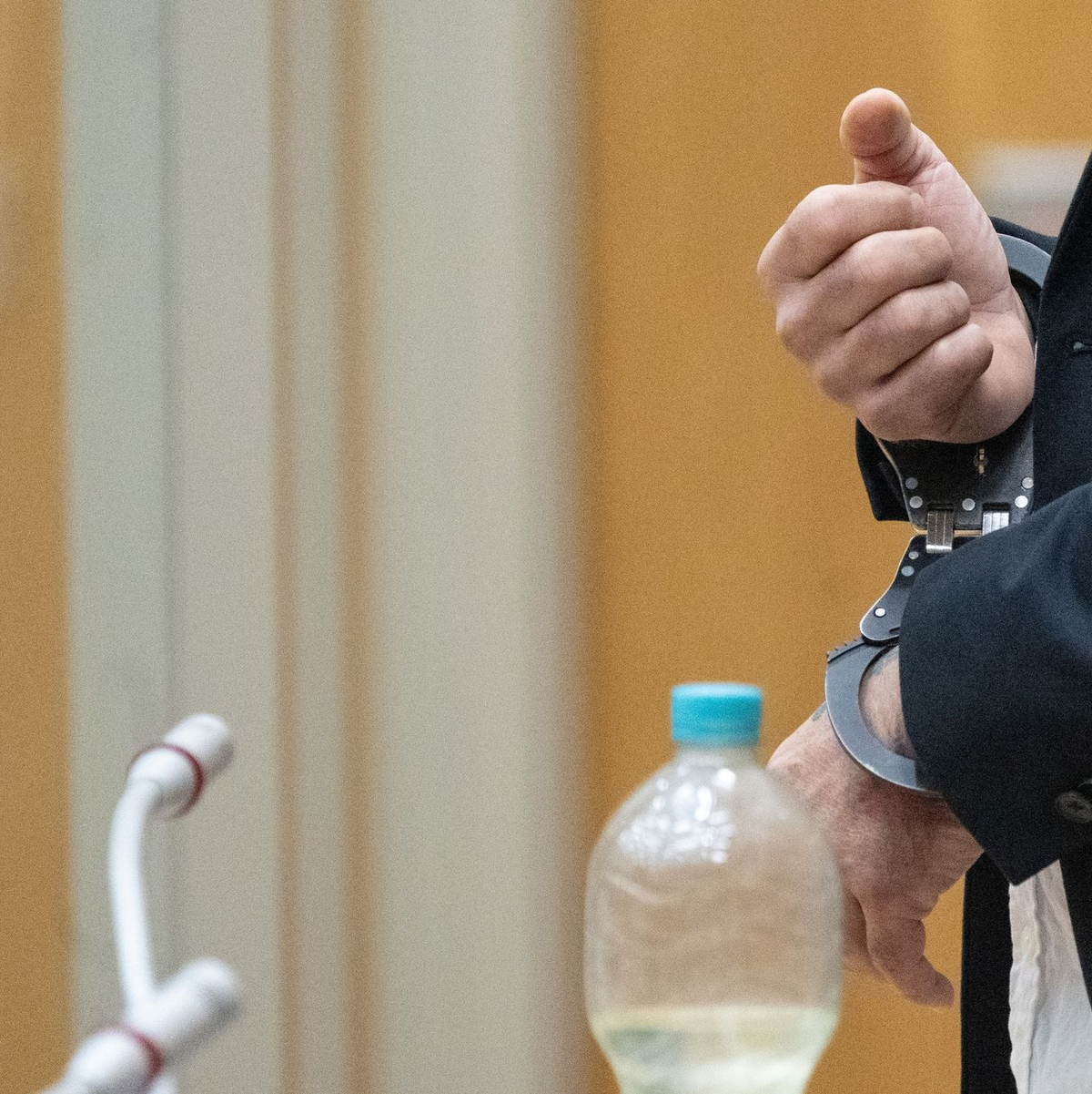 Der Angeklagte steht in Handschellen in einem Saal des Oberlandesgerichts Stuttgart. - Foto: -/dpa