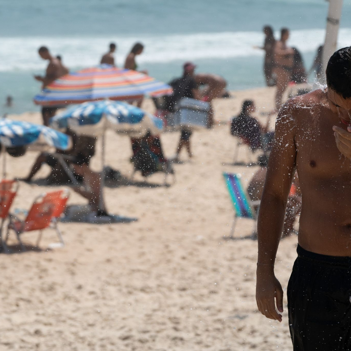 Ein Mann duscht am Strand von Ipanema. Brasilien wird derzeit von einer Hitzewelle heimgesucht. - Foto: Wang Tiancong/XinHua/dpa
