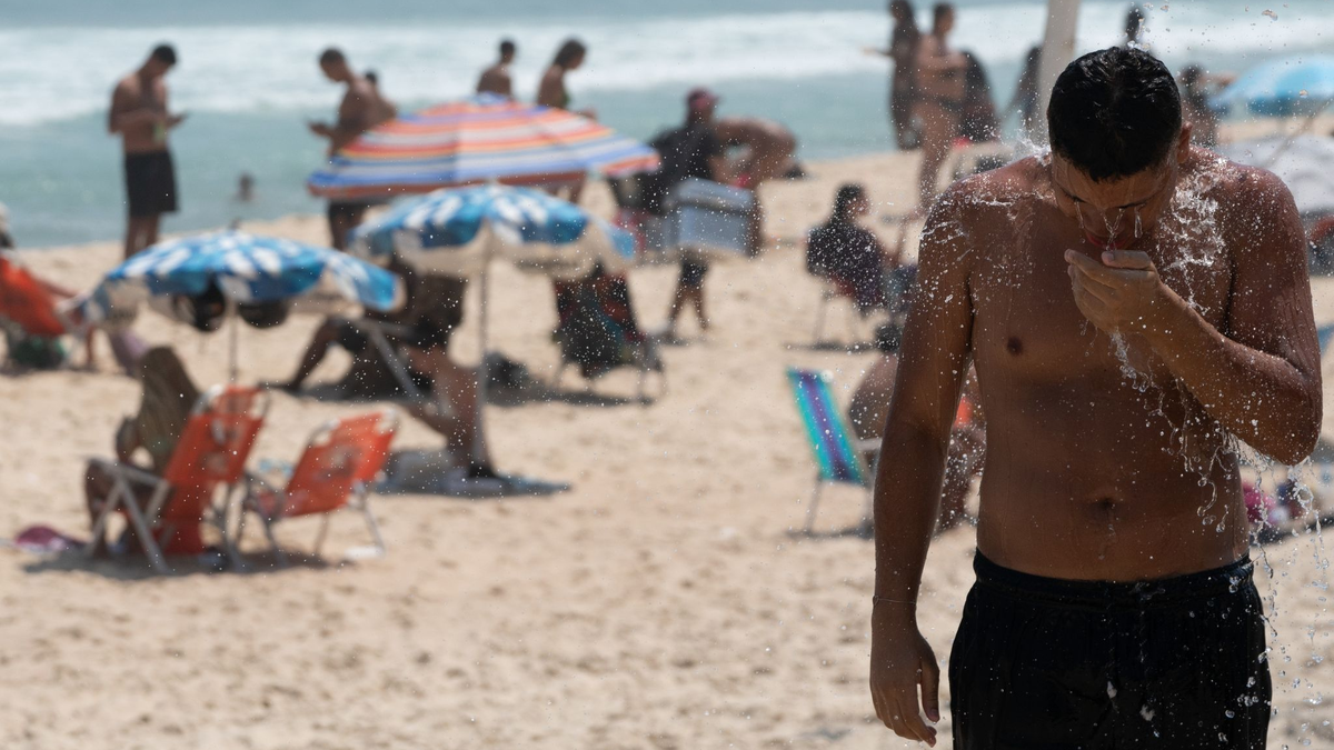 Ein Mann duscht am Strand von Ipanema. Brasilien wird derzeit von einer Hitzewelle heimgesucht. - Foto: Wang Tiancong/XinHua/dpa