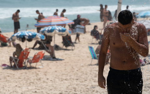 Ein Mann duscht am Strand von Ipanema. Brasilien wird derzeit von einer Hitzewelle heimgesucht. - Foto: Wang Tiancong/XinHua/dpa