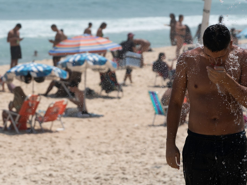 Ein Mann duscht am Strand von Ipanema. Brasilien wird derzeit von einer Hitzewelle heimgesucht. - Foto: Wang Tiancong/XinHua/dpa