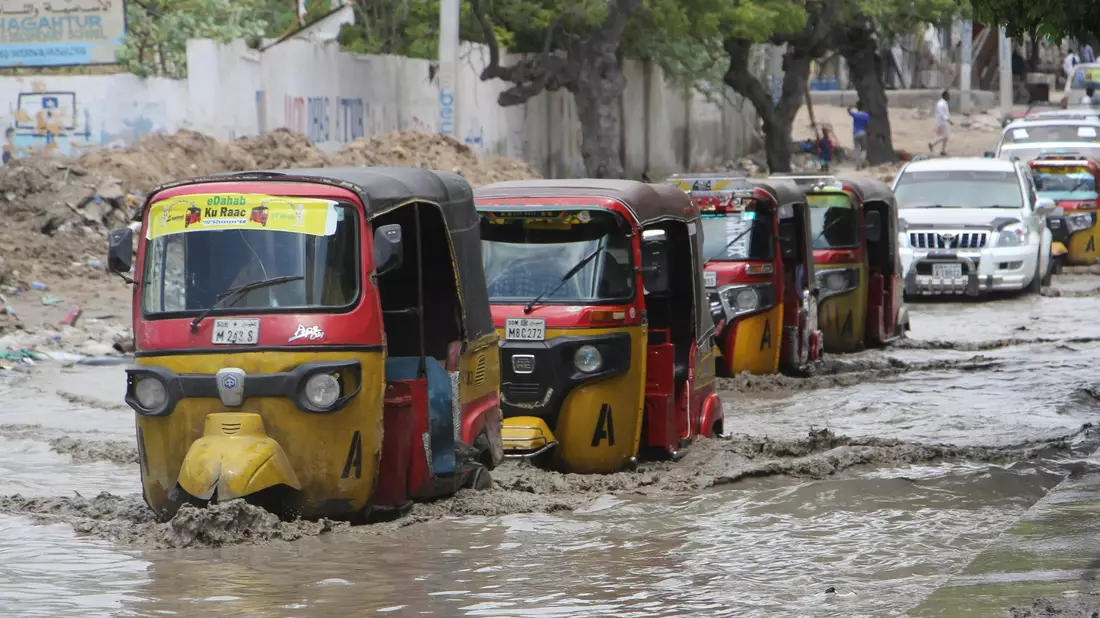 Tuktuks fahren durch eine überflutete Straße nach starkem Regen in Mogadischu. - Bild: Farah Abdi Warsameh/AP/dpa