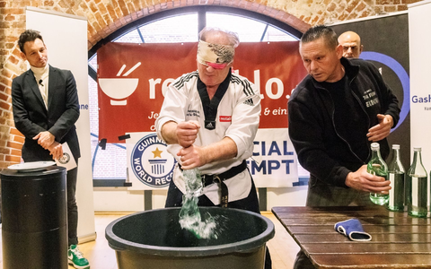 Der Kampfsportler Muhamed Kahrimanovic beim Versuch, mit verbundenen Augen und einem rohen Ei in der Hand Glasflaschen zu zerschlagen. - Foto: Markus Scholz/dpa Der Kampfsportler Muhamed Kahrimanovic beim Versuch, mit verbundenen Augen und einem rohen Ei in der Hand Glasflaschen zu zerschlagen. - Foto: Markus Scholz/dpa