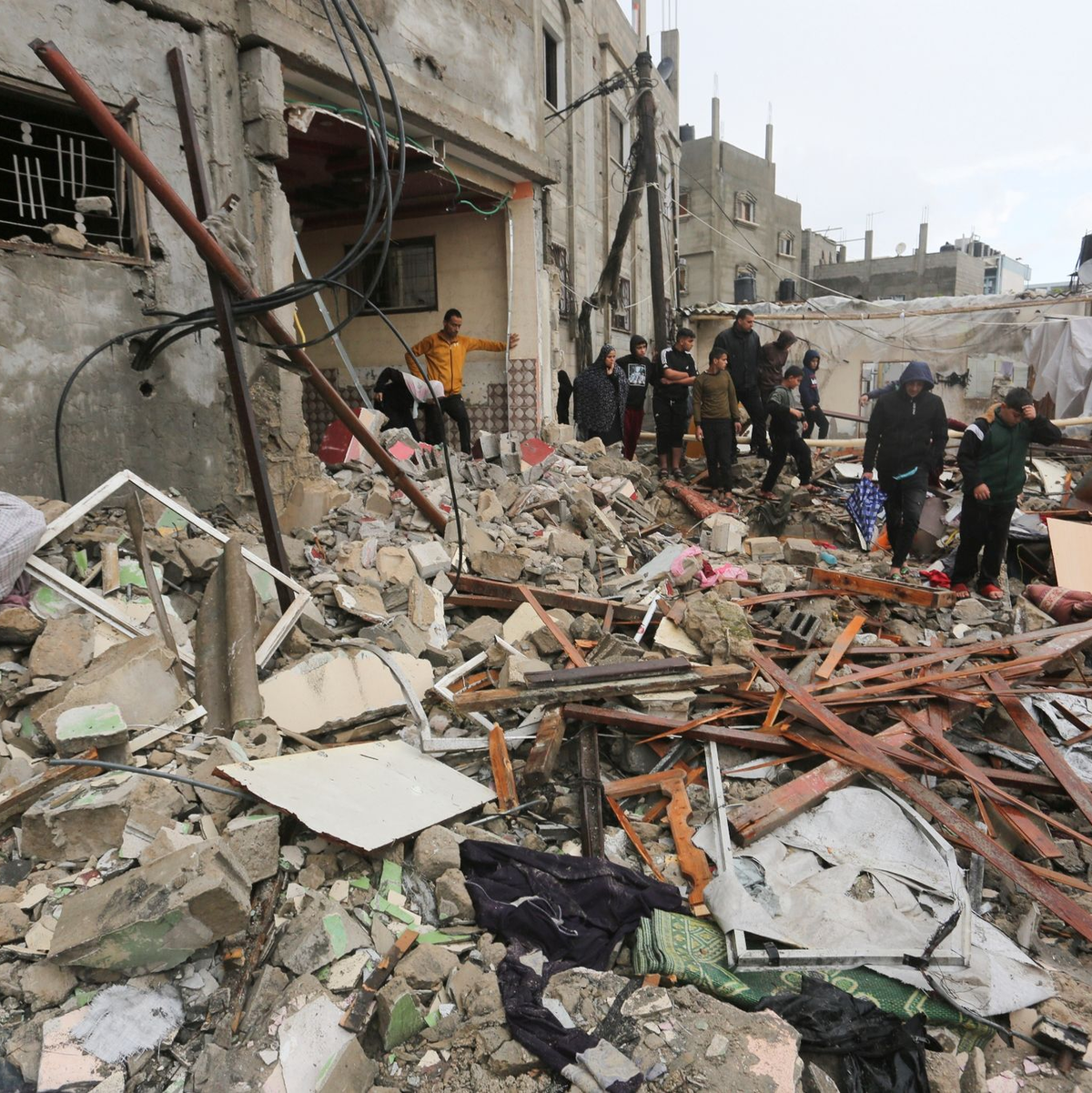 Palästinenser suchen in den Trümmern eines Gebäudes nach Überlebenden. - Foto: Hatem Ali/AP