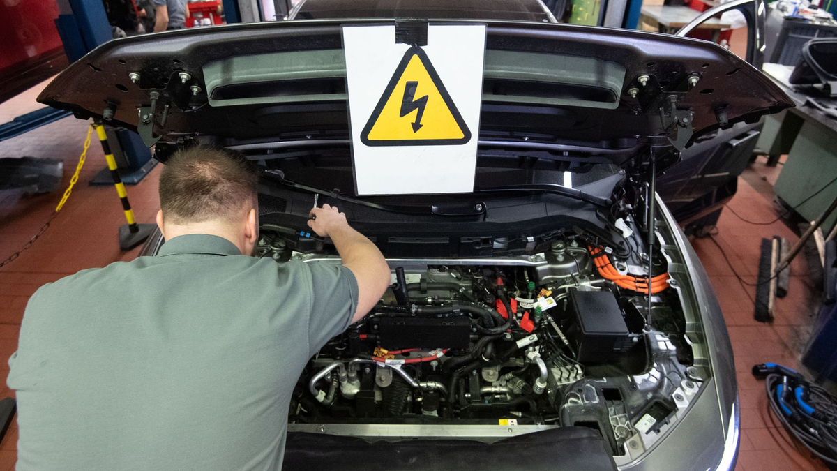 Ein KFZ-Mechaniker wartet ein E-Auto. - Foto: Marijan Murat/dpa