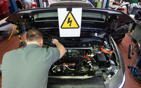Ein KFZ-Mechaniker wartet ein E-Auto. - Foto: Marijan Murat/dpa
