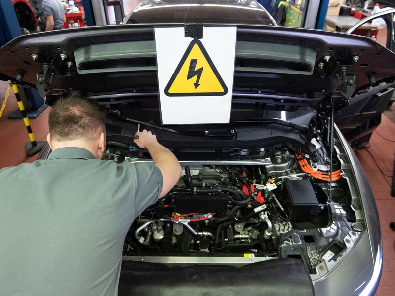 Ein KFZ-Mechaniker wartet ein E-Auto. - Foto: Marijan Murat/dpa