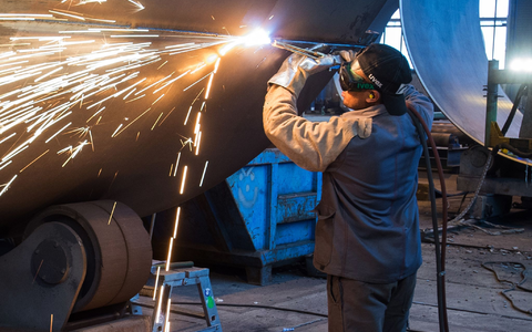 Ein Mann aus Somalia, der zuvor als Schweißer ausgebildet wurde, arbeitet in einer Firma an einem Stahlsegment. - Foto: Patrick Pleul/ZB/dpa