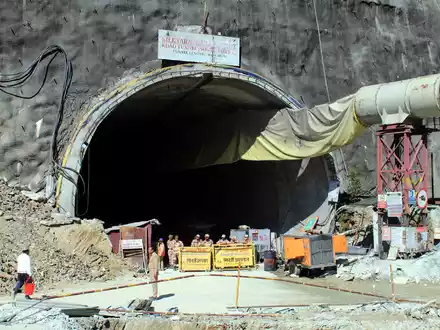 Menschen beobachten Rettungs- und Hilfsmaßnahmen an der Stelle eines im Bau befindlichen Straßentunnels, der im indischen Bundesstaat Uttarakhand eingestürzt ist. - Foto: Uncredited/AP/dpa