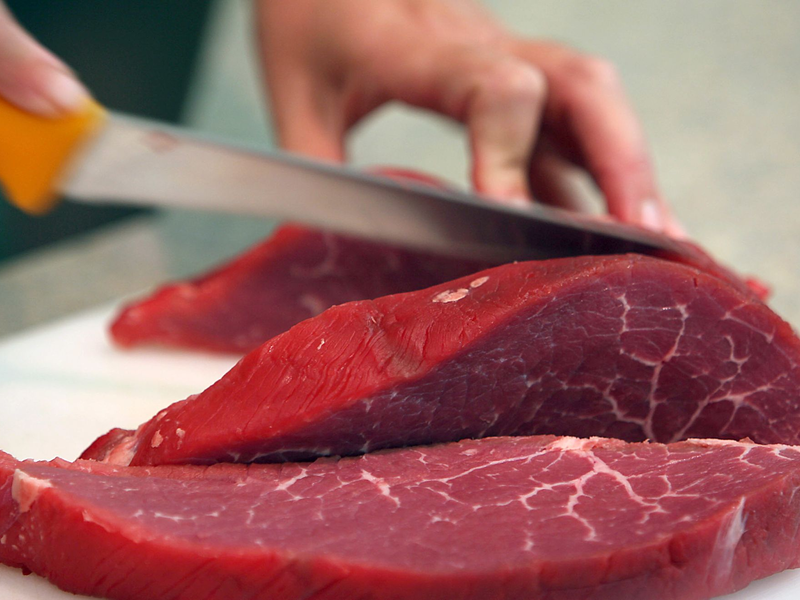 Rindfleisch wird geschnitten: Italien verbietet die Herstellung und den Verkauf von Laborfleisch. - Foto: Oliver Berg/dpa